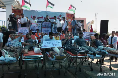 Palestinians who were wounded by Israeli troops during clashes at Israeli-Gaza border, take part in a protest to demand their rights to travel for treatment and against the siege on the Gaza Strip, at Erez crossing, in t...