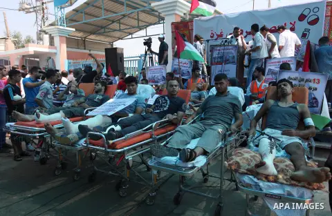 Palestinians who were wounded by Israeli troops during clashes at Israeli-Gaza border, take part in a protest to demand their rights to travel for treatment and against the siege on the Gaza Strip, at Erez crossing, in t...
