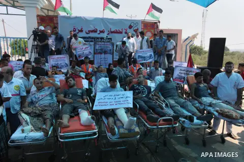 Palestinians who were wounded by Israeli troops during clashes at Israeli-Gaza border, take part in a protest to demand their rights to travel for treatment and against the siege on the Gaza Strip, at Erez crossing, in t...