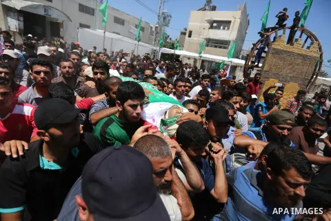 Mourners carry the body of Palestinian militant Mohammed Abu Dakah, 31, who was killed in an Israeli strike, during his funeral in Khan Younis in the southern of Gaza Strip, on July 21, 2018. Photo by Ashraf Amra