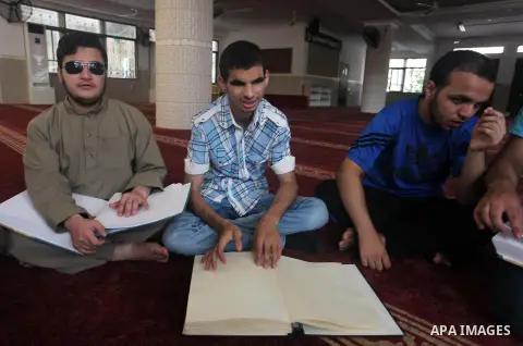 Palestinian blind boys read and memorise the holy Quran in braille at Dar al-Quran and Sunnah in Gaza city, on July 23, 2018. Photo by Mahmoud Ajour