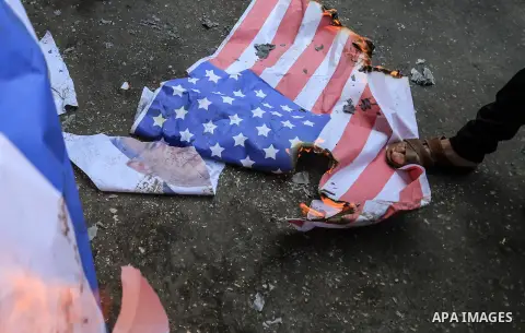 Palestinian supporters of the Islamic Jihad movement burn an Israeli flag and American Flag during a protest to show solidarity with Al-Aqsa mosque, in Gaza city, on July 23, 2018. Photo by Dawoud Abo Alkas