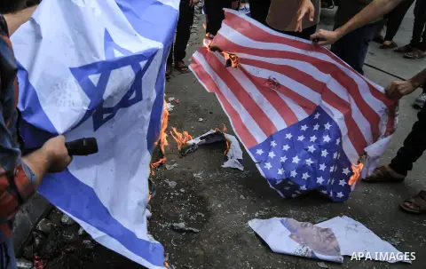 Palestinian supporters of the Islamic Jihad movement burn an Israeli flag and American Flag during a protest to show solidarity with Al-Aqsa mosque, in Gaza city, on July 23, 2018. Photo by Dawoud Abo Alkas