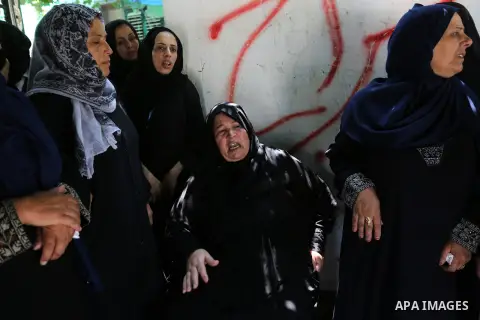 Relatives of Palestinian Karam Arafat,23, who died of wounds he sustained during clashes with Israeli troops, mourn during his funeral in Khan Younis in the southern of Gaza strip on July 23, 2018. Photo by Ashraf Amra