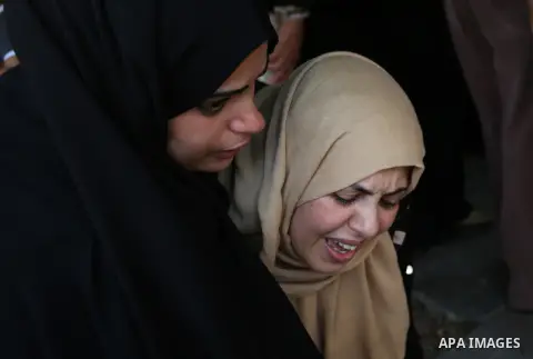 Relatives of Palestinian Karam Arafat,23, who died of wounds he sustained during clashes with Israeli troops, mourn during his funeral in Khan Younis in the southern of Gaza strip on July 23, 2018. Photo by Ashraf Amra