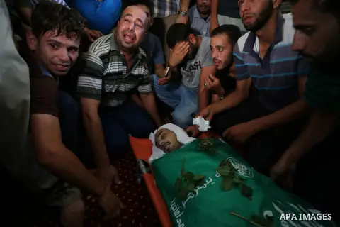Relatives of Palestinian Karam Arafat,23, who died of wounds he sustained during clashes with Israeli troops, mourn over his body during his funeral in Khan Younis in the southern of Gaza strip on July 23, 2018. Photo by...