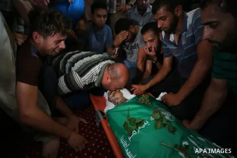 Relatives of Palestinian Karam Arafat,23, who died of wounds he sustained during clashes with Israeli troops, mourn over his body during his funeral in Khan Younis in the southern of Gaza strip on July 23, 2018. Photo by...