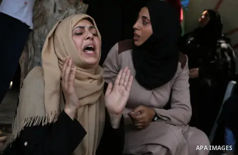 Relatives of Palestinian Karam Arafat,23, who died of wounds he sustained during clashes with Israeli troops, mourn during his funeral in Khan Younis in the southern of Gaza strip on July 23, 2018. Photo by Ashraf Amra