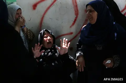Relatives of Palestinian Karam Arafat,23, who died of wounds he sustained during clashes with Israeli troops, mourn during his funeral in Khan Younis in the southern of Gaza strip on July 23, 2018. Photo by Ashraf Amra