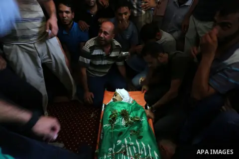 Relatives of Palestinian Karam Arafat,23, who died of wounds he sustained during clashes with Israeli troops, mourn over his body during his funeral in Khan Younis in the southern of Gaza strip on July 23, 2018. Photo by...