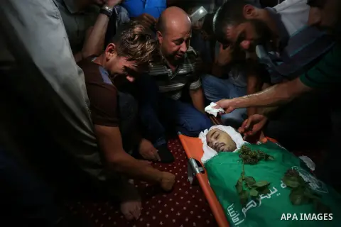 Relatives of Palestinian Karam Arafat,23, who died of wounds he sustained during clashes with Israeli troops, mourn over his body during his funeral in Khan Younis in the southern of Gaza strip on July 23, 2018. Photo by...