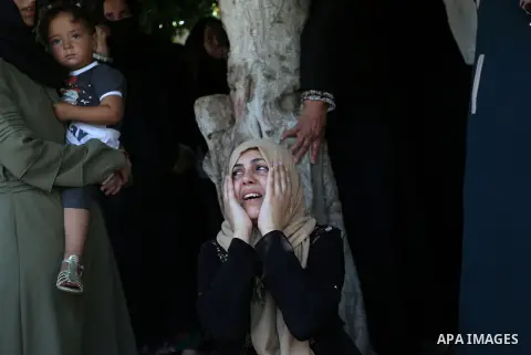 Relatives of Palestinian Karam Arafat,23, who died of wounds he sustained during clashes with Israeli troops, mourn during his funeral in Khan Younis in the southern of Gaza strip on July 23, 2018. Photo by Ashraf Amra