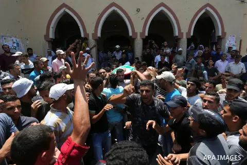 Mourners carry the body of Palestinian Karam Arafat, who died of wounds he sustained during clashes with Israeli troops, during his funeral in Khan Younis in the southern of Gaza strip on July 23, 2018. Photo by Ashraf A...