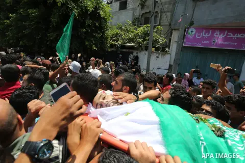 Mourners carry the body of Palestinian Karam Arafat, who died of wounds he sustained during clashes with Israeli troops, during his funeral in Khan Younis in the southern of Gaza strip on July 23, 2018. Photo by Ashraf A...