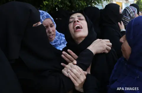 Relatives of Palestinian Karam Arafat,23, who died of wounds he sustained during clashes with Israeli troops, mourn during his funeral in Khan Younis in the southern of Gaza strip on July 23, 2018. Photo by Ashraf Amra