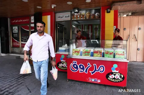 A Palestinian man buys ice-cream (sundae) during a heatwave in Gaza city on July 25, 2018. Photo by Mahmoud Ajour