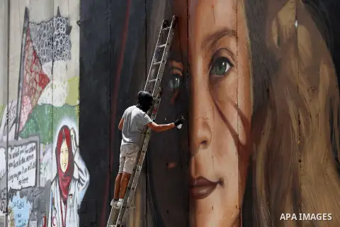 Italian artist Jorit Agoch paints a mural depicting Palestinian teenager Ahed Tamimi on Israel's controversial separation barrier in the West Bank city of Bethlehem, on July 25,2018. Tamimi, was charged earlier this year...