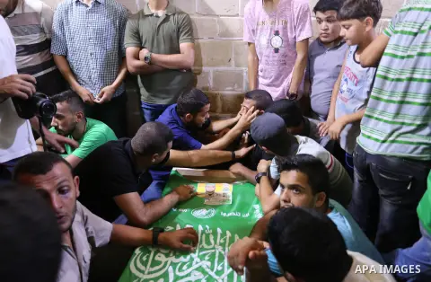 Mourners gather around the body of Palestinian Hamas militant Ahmed Albassous who was killed in Israeli tank fire, during his funeral at Omari Mosque in Gaza City July 26, 2018. Photo by Ashraf Amra