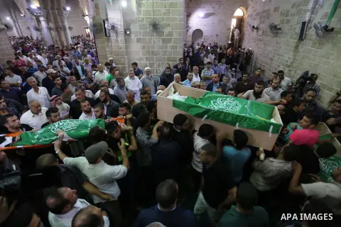 Mourners carry the bodies of Palestinian Hamas militants who were killed in Israeli tank fire, during their funeral at Omari Mosque in Gaza City July 26, 2018. Photo by Ashraf Amra