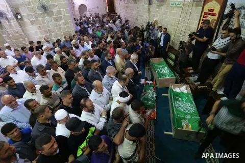 Mourners pray on the bodies of Hamas militants who were killed in Israeli tank fire, during their funeral l at Omari Mosque in Gaza City July 26, 2018. Photo by Ashraf Amra