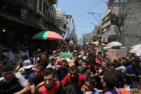 Mourners carry the bodies of Palestinian Hamas militants who were killed in Israeli tank fire, during their funeral in Gaza City July 26, 2018. Photo by Ashraf Amra