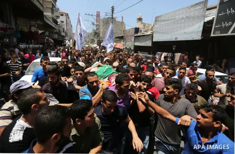 Mourners carry the bodies of Palestinian Hamas militants who were killed in Israeli tank fire, during their funeral in Gaza City July 26, 2018. Photo by Ashraf Amra