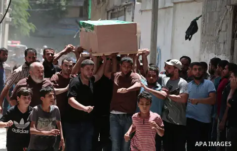 Mourners carry the body of Palestinian Hamas militant Obada Farwana, who was killed in Israeli tank fire, during his funeral in Gaza City on July 26, 2018. Photo by Ashraf Amra