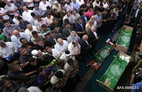 Mourners pray on the bodies of Hamas militants who were killed in Israeli tank fire, during their funeral l at Omari Mosque in Gaza City July 26, 2018. Photo by Ashraf Amra