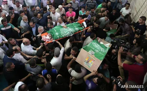 Mourners carry the bodies of Palestinian Hamas militants who were killed in Israeli tank fire, during their funeral at Omari Mosque in Gaza City July 26, 2018. Photo by Ashraf Amra