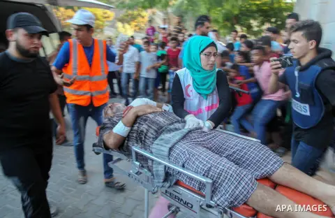 A Palestinian who was wounded during clashes with Israeli troops at Gaza-Israel border is carried on stretcher outside a hospital, in Jabalia in the northern of Gaza Strip on July 27, 2018. Photo by Ramez Habboub