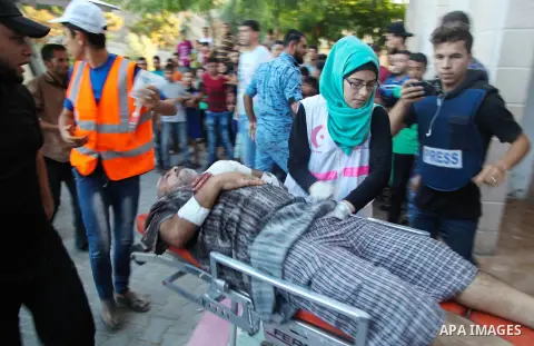 A Palestinian who was wounded during clashes with Israeli troops at Gaza-Israel border is carried on stretcher outside a hospital, in Jabalia in the northern of Gaza Strip on July 27, 2018. Photo by Ramez Habboub