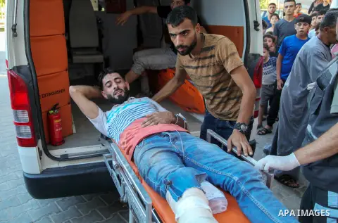 A Palestinian who was wounded during clashes with Israeli troops at Gaza-Israel border is carried on stretcher outside a hospital, in Jabalia in the northern of Gaza Strip on July 27, 2018. Photo by Ramez Habboub