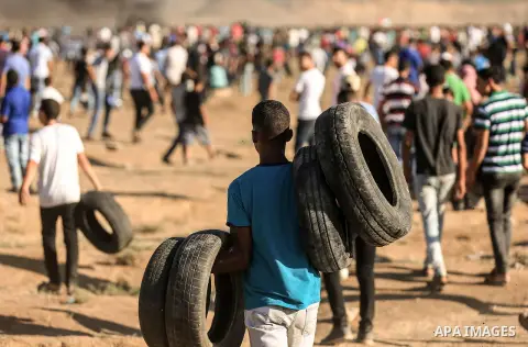 Palestinian protesters gather during clashes with Israeli troops in tents protest where Palestinian demand the right to return to their homeland at the Israel-Gaza border, in east of Gaza City on July 27, 2018. Photo by...