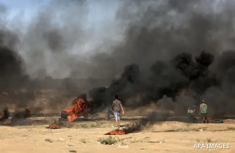 Palestinian protesters gather during clashes with Israeli troops in tents protest where Palestinian demand the right to return to their homeland at the Israel-Gaza border, in east of Gaza City on July 27, 2018. Photo by...