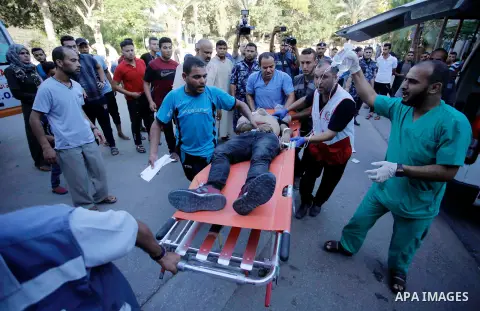 A Palestinian who was wounded during clashes with Israeli troops at Gaza-Israel border is carried on stretcher outside a hospital, in Khan Younis in the southern of Gaza Strip on July 27, 2018. Photo by Ramadan Elagha