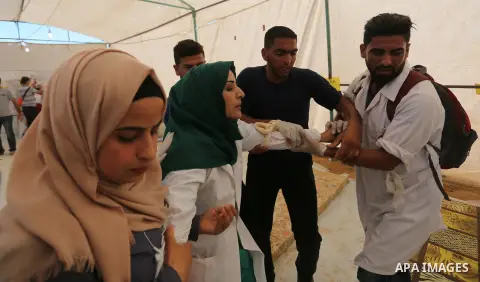 Injured Palestinian protestors receive treatment at a medical tent during clashes with Israeli security forces in tents protest where Palestinian demand the right to return to their homeland at the Israel-Gaza border, in...