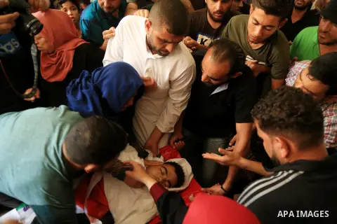 Relatives of Palestinian Mohmen al-Hams, 17, who died of wounds after being shot by Israeli troops during clashes along the border the previous day mourn over his body during his funeral in the Rafah refugee camp in the...
