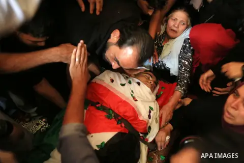 Relatives of Palestinian Mohmen al-Hams, 17, who died of wounds after being shot by Israeli troops during clashes along the border the previous day mourn over his body during his funeral in the Rafah refugee camp in the...