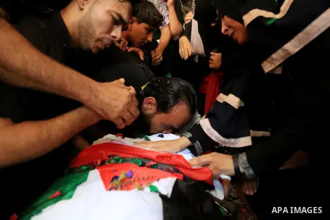 Relatives of Palestinian Mohmen al-Hams, 17, who died of wounds after being shot by Israeli troops during clashes along the border the previous day mourn over his body during his funeral in the Rafah refugee camp in the...