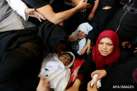 Relatives of Palestinian Mohmen al-Hams, 17, who died of wounds after being shot by Israeli troops during clashes along the border the previous day mourn over his body during his funeral in the Rafah refugee camp in the...