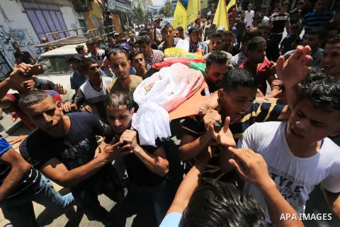 Mourners carry the body of Palestinian Ghazi Abu Mustafa, 43, who was shot dead by Israeli troops during clashes along the border the previous day, carry his body during his funeral in Khan Younis in the southern Gaza St...