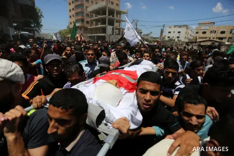 Mourners carry the body of Palestinian Majdi al-Sutari, 11, who was shot dead by Israeli troops during clashes along the border the previous day, during his funeral in Rafah in the southern Gaza Strip on July 28, 2018. P...