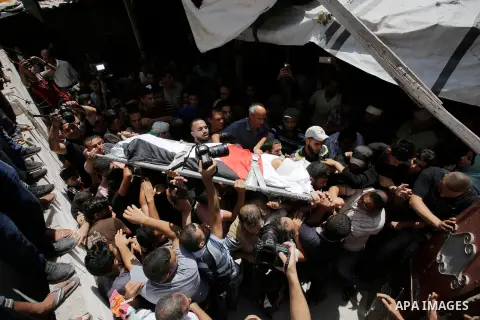 Mourners carry the body of Majdi al-Sutari, 11, who was shot dead by Israeli troops during clashes along the border the previous day, during his funeral in Rafah in the southern Gaza Strip on July 28, 2018. Photo by Rama...