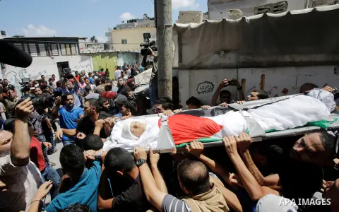 Mourners carry the body of Majdi al-Sutari, 11, who was shot dead by Israeli troops during clashes along the border the previous day, during his funeral in Rafah in the southern Gaza Strip on July 28, 2018. Photo by Rama...