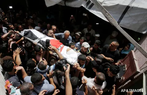 Mourners carry the body of Majdi al-Sutari, 11, who was shot dead by Israeli troops during clashes along the border the previous day, during his funeral in Rafah in the southern Gaza Strip on July 28, 2018. Photo by Rama...