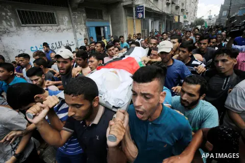 Mourners carry the body of Majdi al-Sutari, 11, who was shot dead by Israeli troops during clashes along the border the previous day, during his funeral in Rafah in the southern Gaza Strip on July 28, 2018. Photo by Rama...