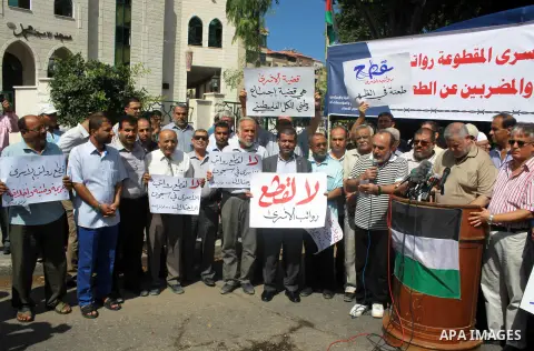 Palestinians take part in a protest to show solidarity with Palestinian prisoners are paid their salaries in Iseali jails in front of the Council of Ministers headcuarter in Gaza City, on July 29, 2018. Photo by Bashar Z...
