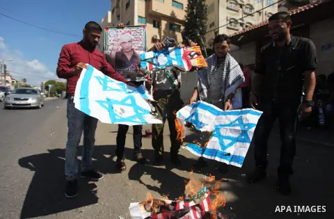 Palestinians burn an Israeli, British and U.S. flags during a protest to show solidarity with Palestinian prisoners held in Israeli jails, in front of Red cross office in Gaza city on July 30, 2018. Photo by Mahmoud Ajou...