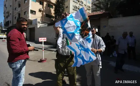 Palestinians burn an Israeli, British and U.S. flags during a protest to show solidarity with Palestinian prisoners held in Israeli jails, in front of Red cross office in Gaza city on July 30, 2018. Photo by Mahmoud Ajou...