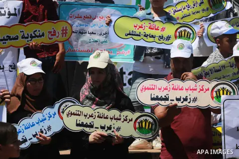 Palestinians hold banners during a protest to demand the built of a hospital in Rafah in the southern Gaza strip on Aug. 01, 2018. Photo by Mahmoud Khattab